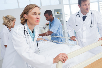 Doctors about to walk with patient bed