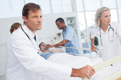 Doctors pushing the bed of a patient