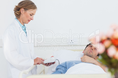 Doctor taking the blood pressure of male patient