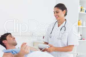 Attractive nurse measuring the blood pressure of a patient