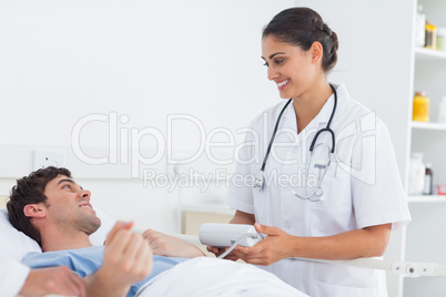 Attractive doctor taking the blood pressure of a patient