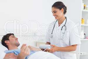 Attractive doctor taking the blood pressure of a patient