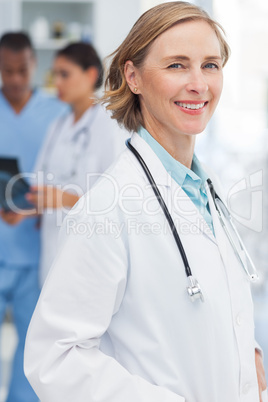 Smiling woman doctor in front of medical team Smiling woman doctor in front of medical team