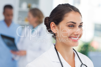 Smiling doctor standing in front of a medical team