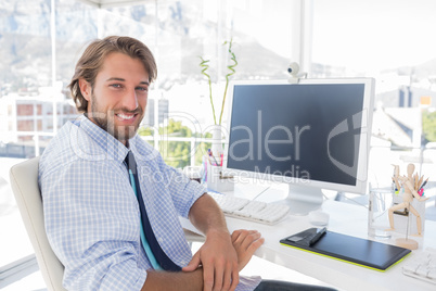 Smiling designer sitting at his desk