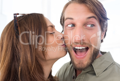 Woman kissing man with beard on the cheek
