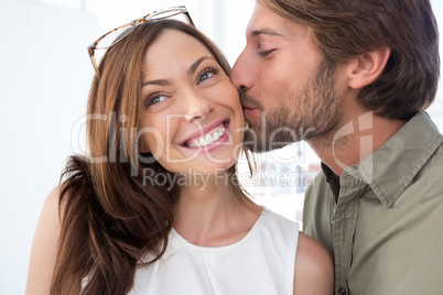 Man kissing pretty woman on the cheek