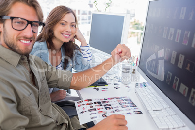 Two smiling photo editors working with contact sheets