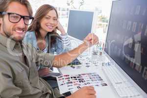 Two smiling photo editors working with contact sheets
