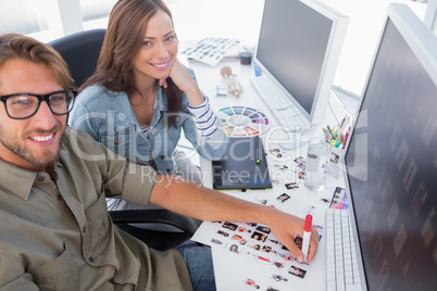 Two happy photo editors working with contact sheets