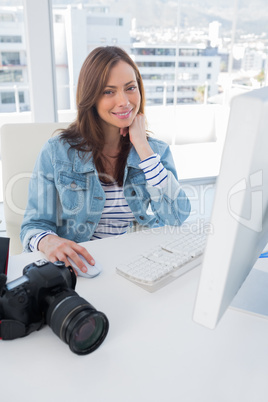 Smiling photographer editing at desk