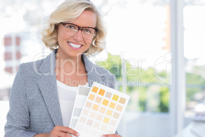 Pretty interior designer holding up colour samples