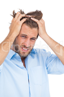 Tanned stressed man holding his hair