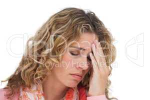 Blonde woman suffering with headache thus holding her head