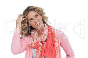 Blonde woman scratching her head and smiling