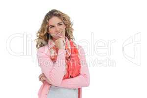 Blonde thoughtful woman smiling while touching her chin