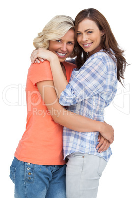 Two cute friends looking at the camera and hugging