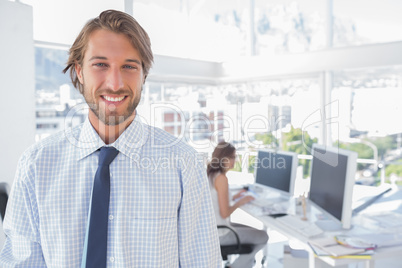 Smiling desginer standing in office