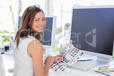 Editor looking over shoulder at camera at her desk