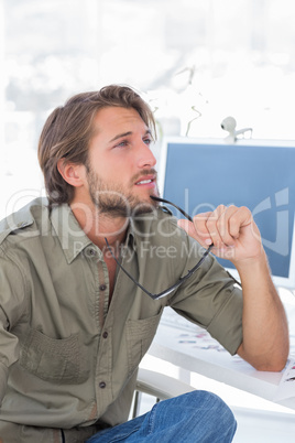 Photo editor thinking at his desk and looking away