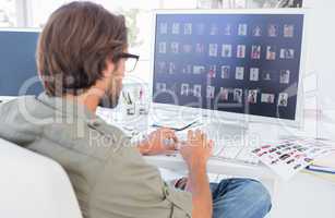 Photo editor looking at thumbnails on computer