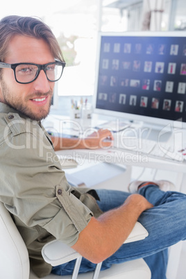 Smiling photo editor at his desk