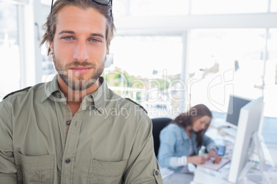 Man standing in creative office with arms folded