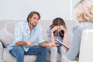 Young couple arguing and crying on the couch