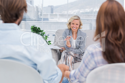 Smiling psychologist talking to a couple