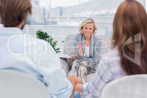 Smiling psychologist talking to a couple