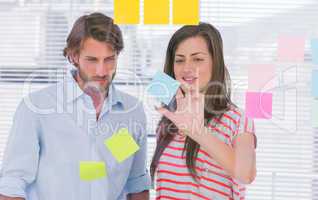 Woman showing the sticky note to her colleague