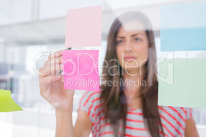 Young woman pointing sticky note with her pen