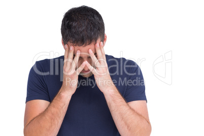 Sad man standing with his head in hands