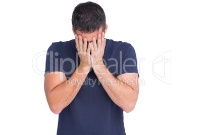 Upset man standing with his head between hands