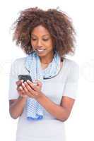 Smiling woman typing a text message on her smartphone