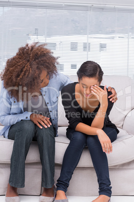 Woman crying next to her therapist