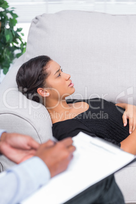 Woman lying down a sofa during a psychotherapy