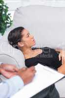 Woman lying down a sofa during a psychotherapy