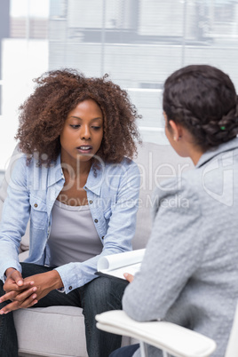 Patient sitting on sofa and talking to therapist