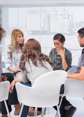 Patients and therapist listening to woman
