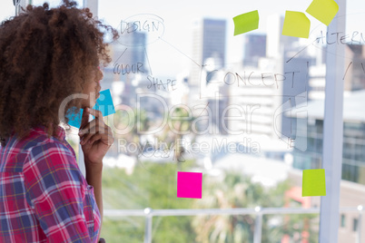 Designer looking at flowchart on window