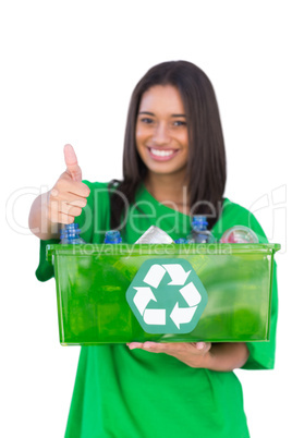 Enivromental activist holding box of recyclables and giving thum