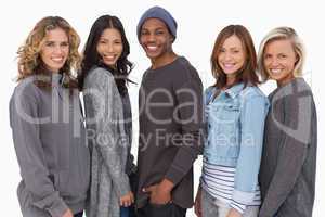 Fashionable young people in a row smiling