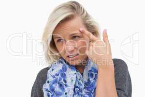 Worried blonde pointing to forehead