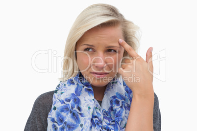 Anxious blonde pointing to forehead