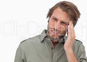 Man with headache looking away and wincing