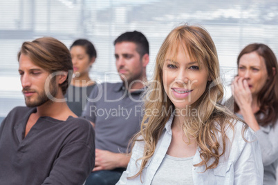 Patients listening in group therapy with one woman smiling