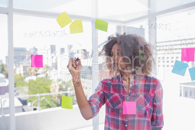 Woman with afro drawing on flowchart with marker