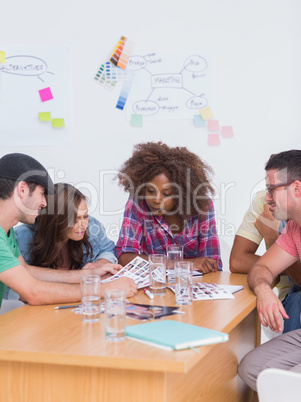 Creative team talking over contact sheets in meeting