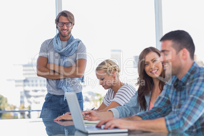 Man standing with arms crossed in creative office